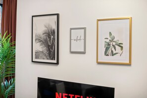 A wall with three framed artworks and a television. - 3 Bedroom Apt Jq Birmingham, Parking & WiFi (Birmingham)