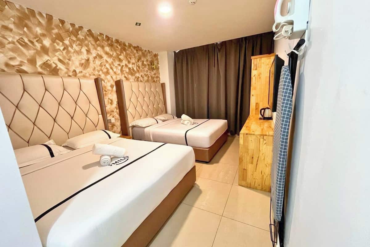 A hotel room with two beds, a wooden cabinet, and a minibar.