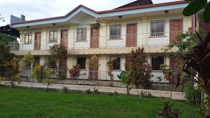 A two-story residential building with a flat roof, multiple windows, and a balcony. - Golden Anchor- Lodge (Coron)