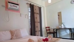 A hotel room with a bed, a desk, and a chair. - Golden Anchor- Lodge (Coron)