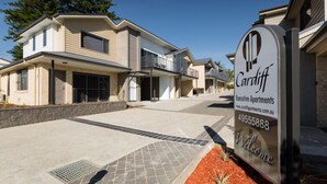 A modern two-story residential building with a sign indicating 'Cardiff Executive Apartments'. - One Bedroom Disability Access (Cardiff)