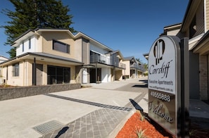 A modern two-story residential building with a sign indicating 'Cardiff Executive Apartments'.