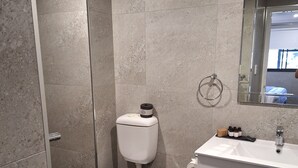 A modern bathroom with a toilet, bidet, and sink. - Two Bedroom Apartment (Newcastle)