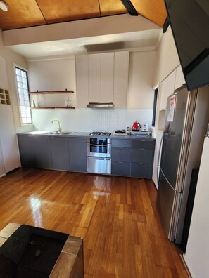 Enjoy cooking in this well-lit kitchen with a stainless steel refrigerator, oven, and sleek cabinetry.