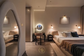Quarto de hotel moderno com uma cama grande, uma escrivaninha com cadeira e duas mesas de cabeceira com abajures.