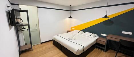 A modern bedroom with a bed, bedside table, desk, and a mirror.
