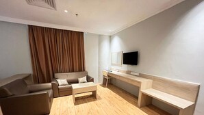 A modern living room with a sofa, a coffee table, a desk, and a TV. - Sky Hotel Chow Kit PWTC (Kuala Lumpur)