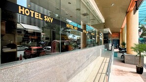 A hotel with a modern glass facade, multiple units, and a covered outdoor area with seating and potted plants. - Sky Hotel Chow Kit PWTC (Kuala Lumpur)