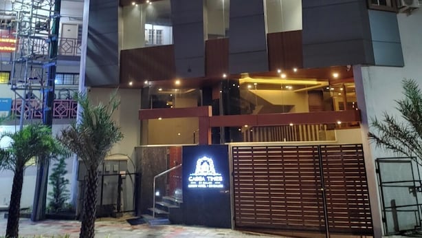Un hotel moderno con una entrada destacada, varios pisos y una fachada bien iluminada.