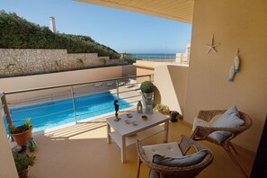 A balcony with a pool, wicker furniture, and a starfish decoration.