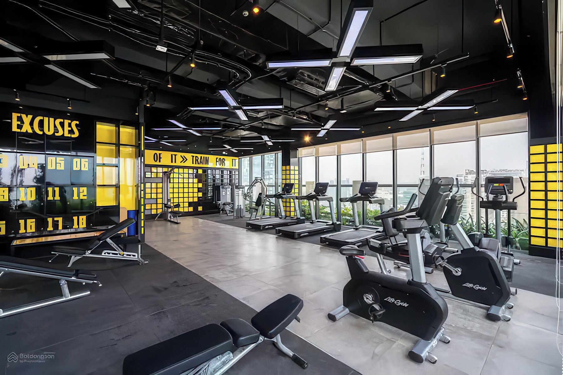 A modern gym with treadmills, elliptical machines, and weight stations.