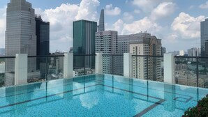 A rooftop infinity pool with a city skyline view, including a Caravelle Hotel. - Salute de Madison Luxury Apt District 1 (Ho Chi Minh City)