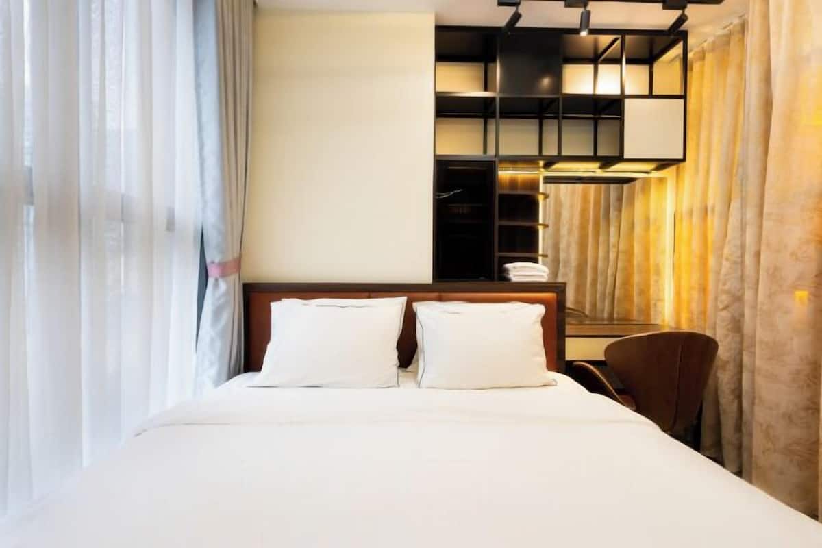 A hotel room with a bed, a desk, and a chair.