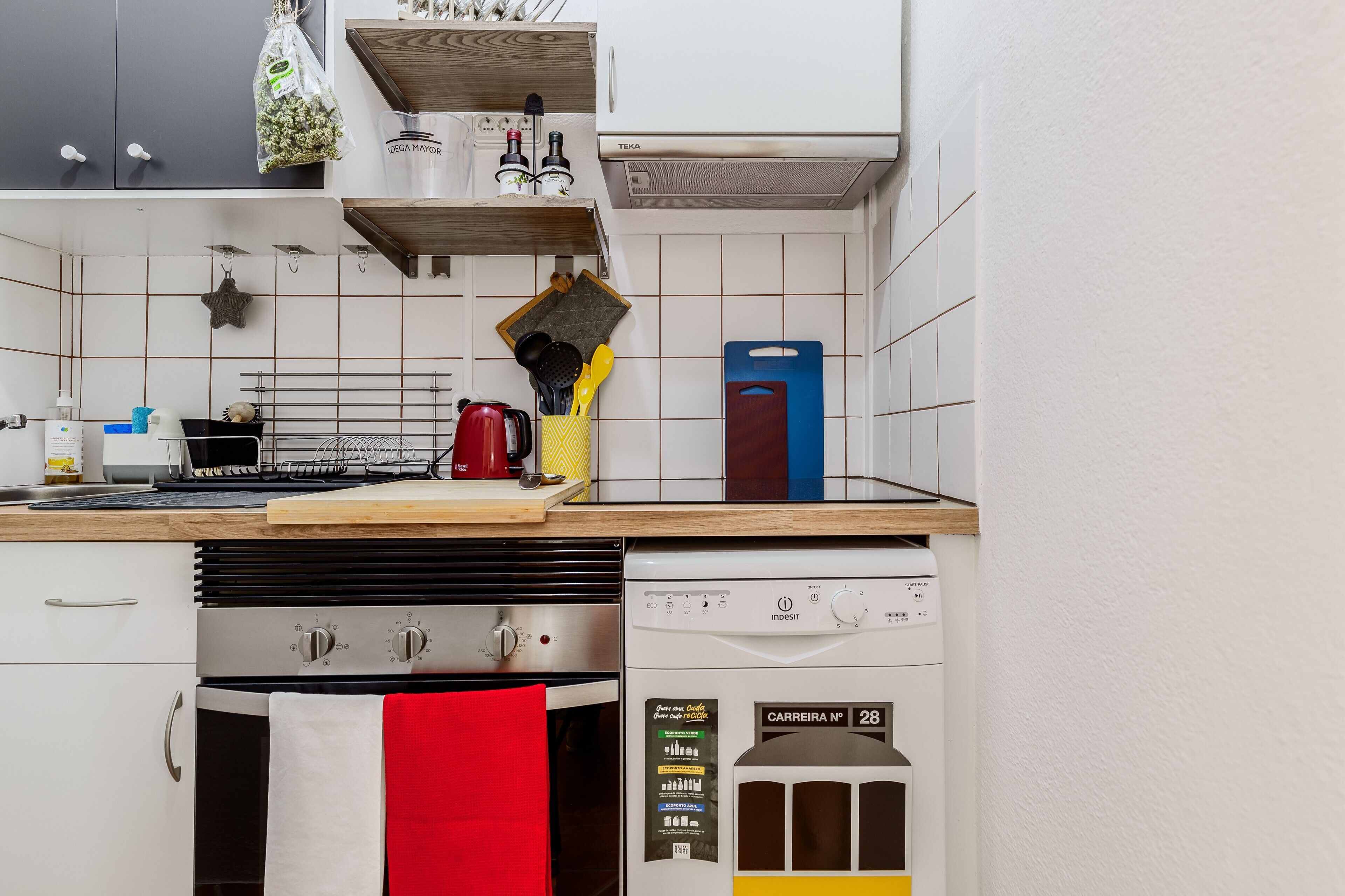 A kitchen with a dishwasher, oven, and various kitchen utensils.