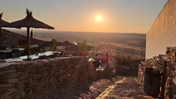 A stone-walled terrace with outdoor seating and a view of the landscape.