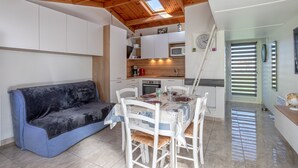 Une cuisine de taille réduite avec des meubles blancs, un four à micro-ondes et un évier.
