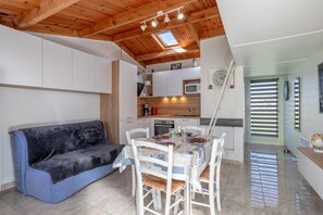 Une cuisine de taille réduite avec des meubles blancs, un four à micro-ondes et un évier.