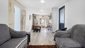 A modern interior with two sofas, a dining table, and a kitchen area.