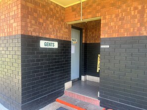 A men's restroom with a sign labeled "GENTS" and a "TOILETS" sign above the door.
