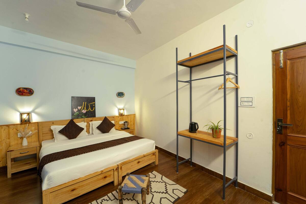 Ein Schlafzimmer mit einem hölzernen Bett, Nachttischen, einem Deckenventilator, einer Wandablage und einer Tür.