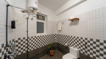 A bathroom with a toilet, sink, and shower.