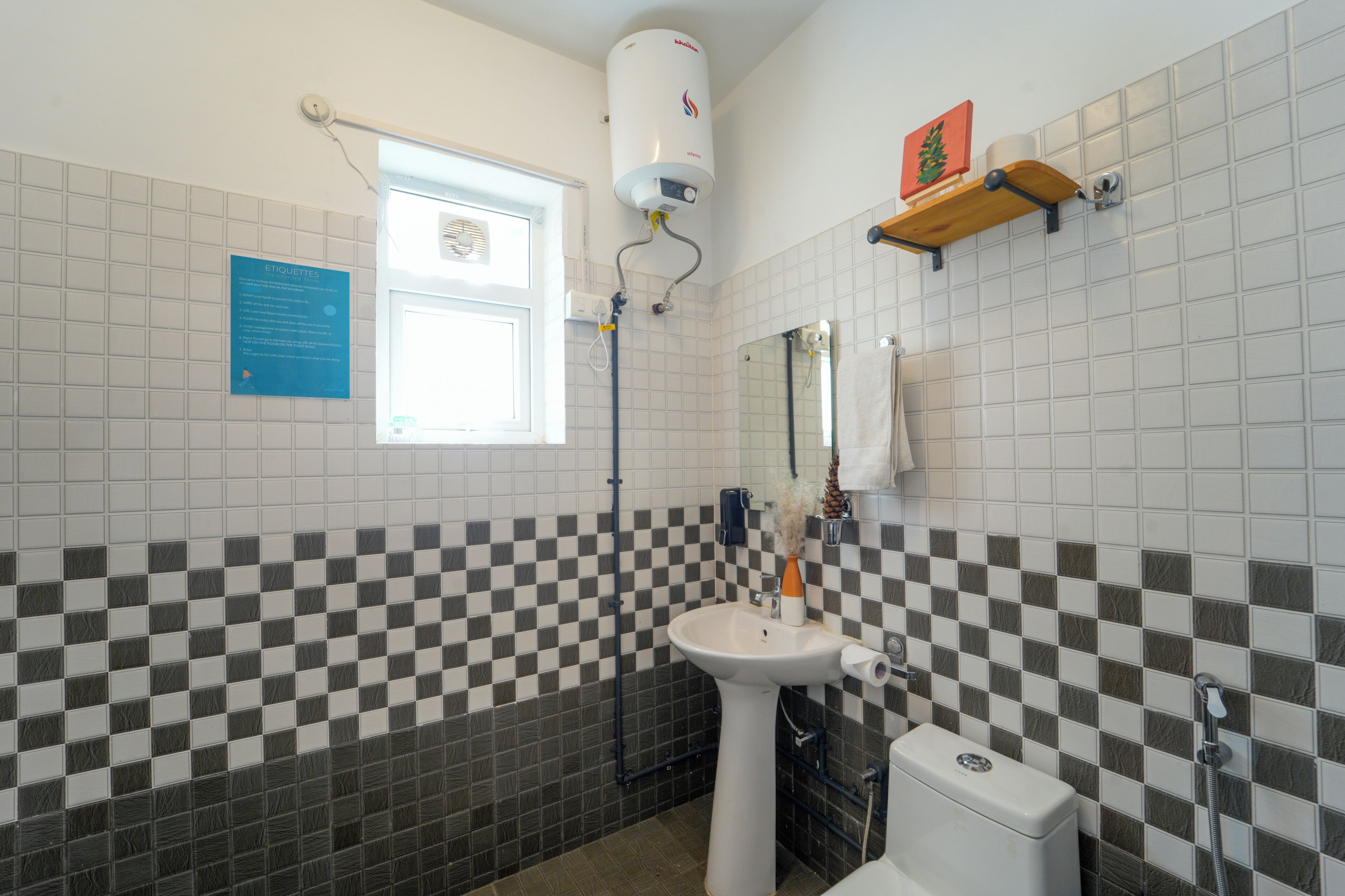 A bathroom with a checkered tile pattern, a white sink, a toilet, a shower, and a towel rack.