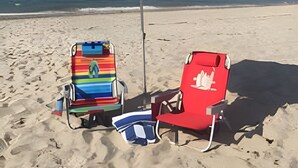 Una playa con dos sillas y un paraguas colorido.