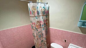 A bathroom with a toilet, sink, and shower curtain with owl designs. - Princesa El Gallo Inn (Puerto Princesa)