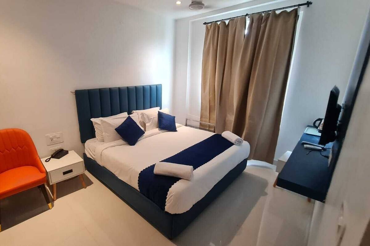 Una habitación de hotel moderna con una cama grande, un escritorio y una silla.