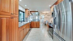 Una cocina moderna con armarios de madera, electrodomésticos de acero inoxidable y una isla central.