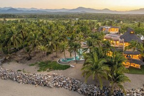 A resort with a pool, palm trees, and a beach area. - Mar de Coco Areca 101 (Playa Blanca)
