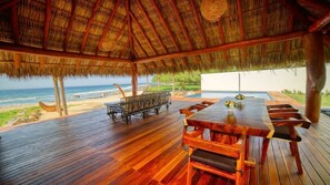 A wooden deck with a thatched roof overlooking the beach. - Beachfront in Manzanillo Bay-Lindo Atardecer (Troncones)