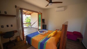 A bedroom with a bed, a chair, a desk, a ceiling fan, and a view of the outside. - Beachfront in Manzanillo Bay-Lindo Atardecer (Troncones)