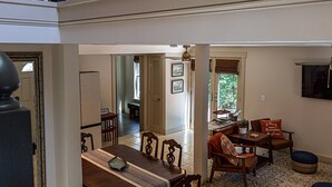 Un amplio salón con una mesa de comedor, sillas y vistas a la cocina.