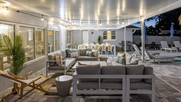 An outdoor patio area with a sofa, chairs, and a dining table.