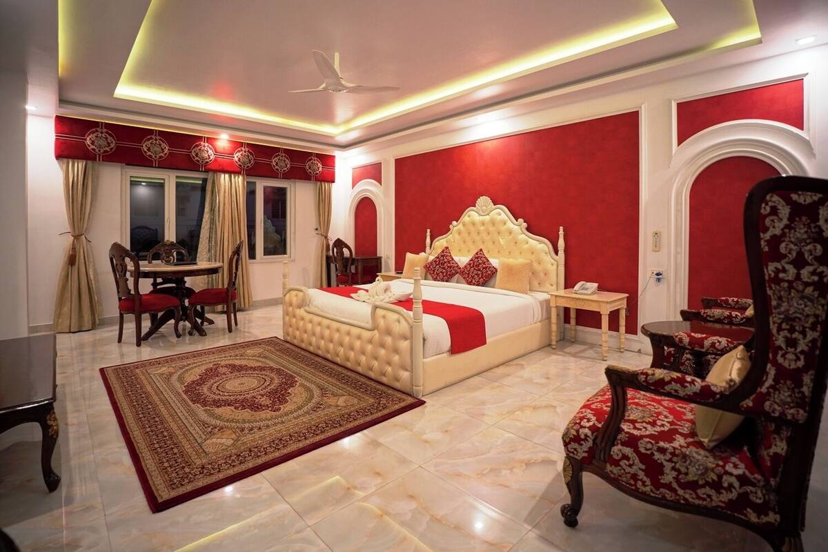 Une chambre spacieuse avec un grand lit, un coin repas et un coin salon.