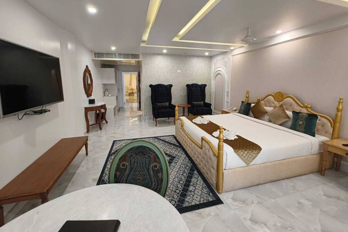 Une chambre d’hôtel moderne dotée d’un grand lit, d’un téléviseur à écran plat, d’un bureau et d’une chaise.