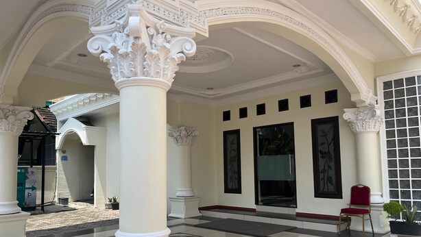 A grand hall with ornate columns, a tiled floor, and a large window with a view of the outdoors. - De Nusantara Hotel Syariah (Medan)