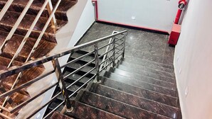 Eine Treppe mit Metallhandlauf und dunklen Marmorstufen.