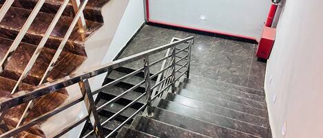 A staircase with a metal handrail and dark marble steps.