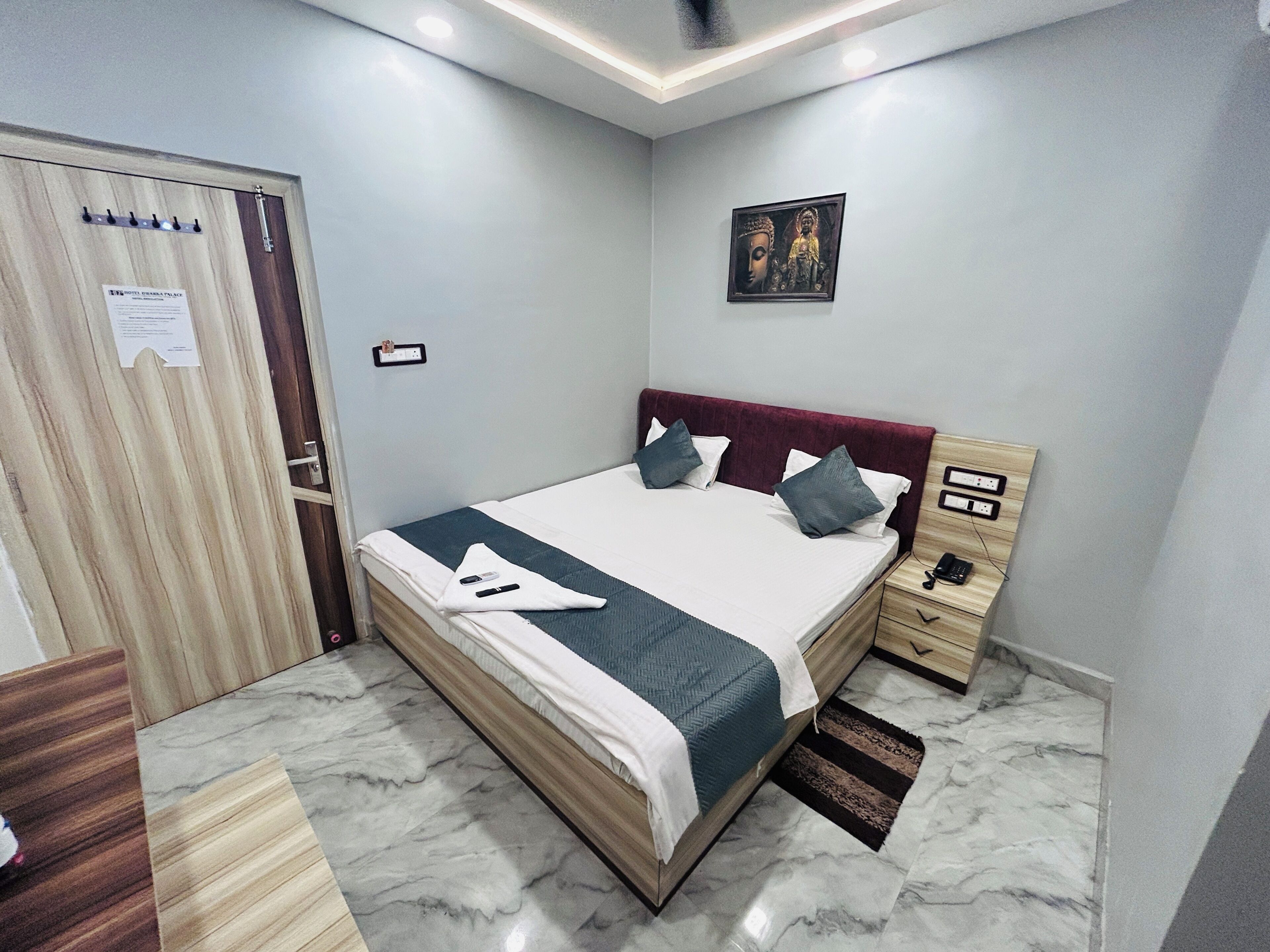 A neatly arranged bedroom with a bed, bedside table, and a wall-mounted picture.