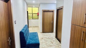 Ein Flur mit einem blauen Sofa, Holzschränken und einer Tür mit der Aufschrift 302.