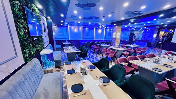 Ein Restaurant mit mehreren Tischen, Stühlen und einem großen Aquarium.
