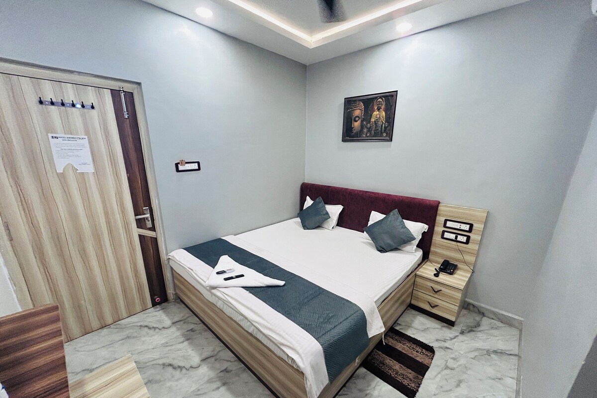 Quarto bem arrumado com cama, mesa de cabeceira e um quadro na parede.