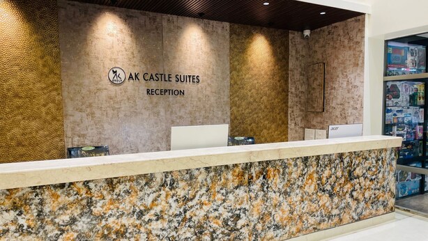 A reception desk at AK Castle Suites with a marble counter and a textured wall behind. - AK CASTLE SUITES (Bengaluru)
