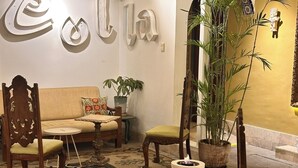 Un soggiorno accogliente con un divano, poltrone, un tavolino e una pianta decorativa.