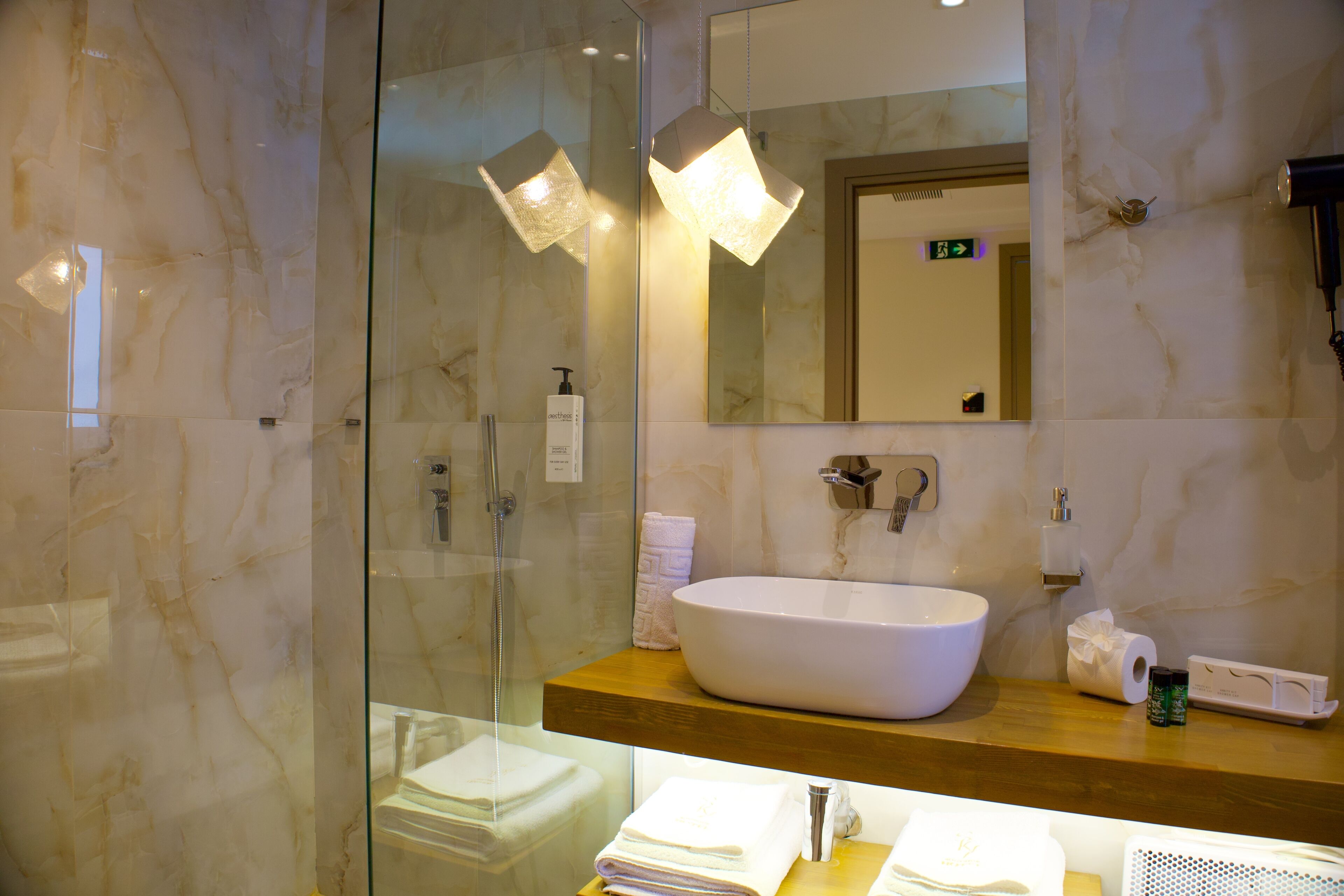 Une salle de bain moderne avec un grand lavabo blanc, une douche en verre et un meuble-lavabo en bois.