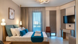 Habitación de hotel moderna con una cama grande, un escritorio, televisión y vistas a la ciudad.