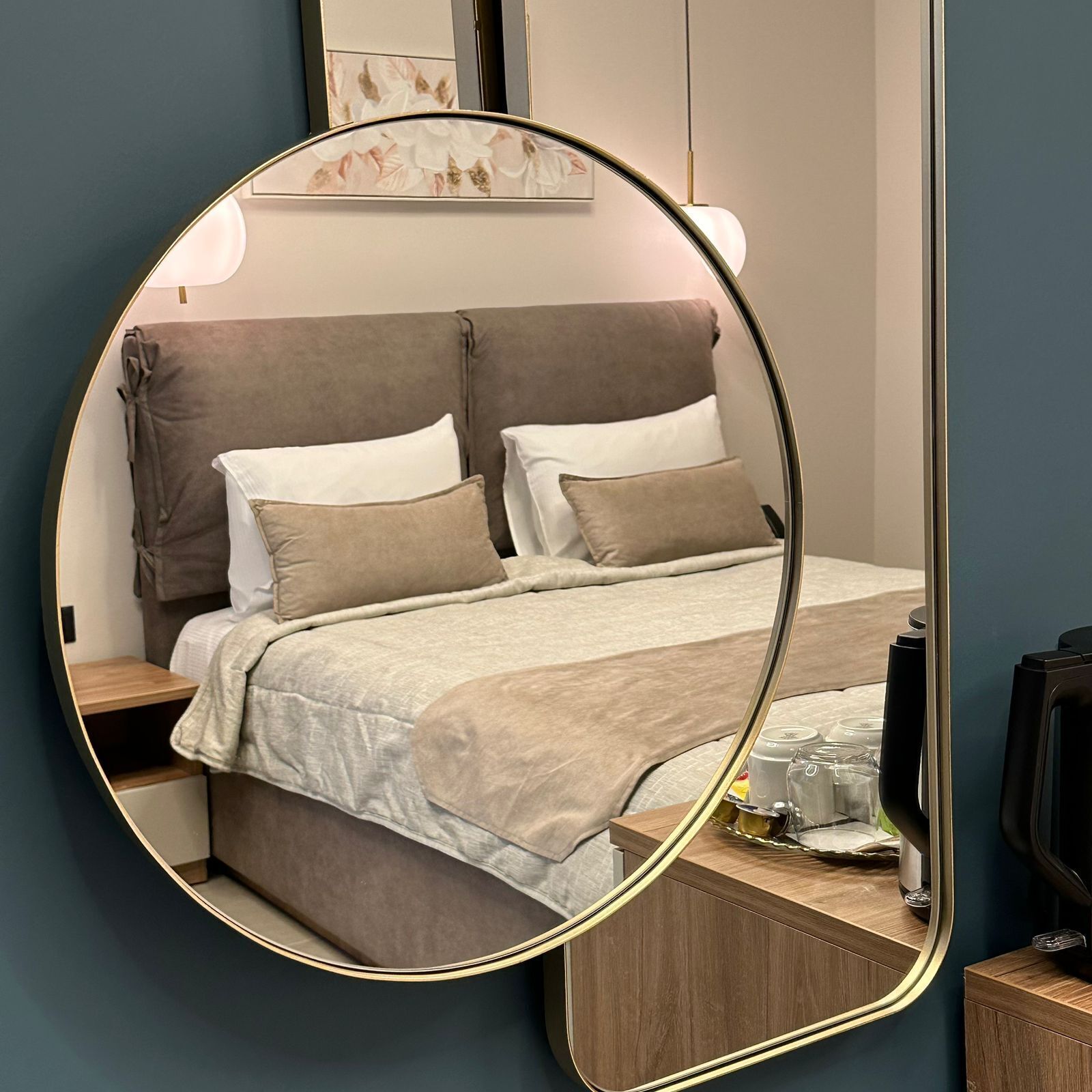 Una camera da letto con un letto, comodini, una cassettiera e uno specchio.