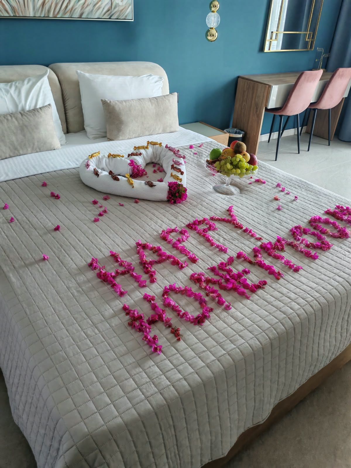 Una cama con una colcha acolchada, un cojín decorativo y un frutero sobre la mesita de noche.